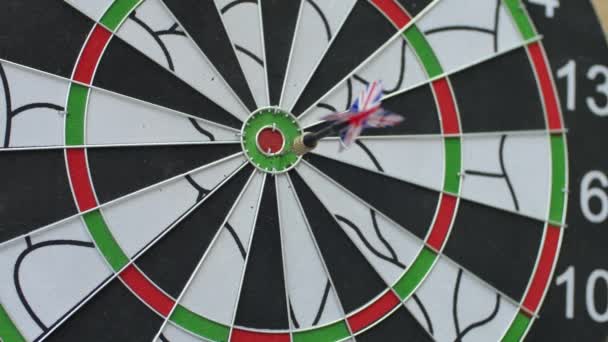 Three darts hitting the bullseye of the dartboard and one missing — Stock Video