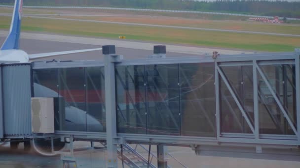 Passagerare ombordstigning på flygplan genom en airbridge. — Stockvideo