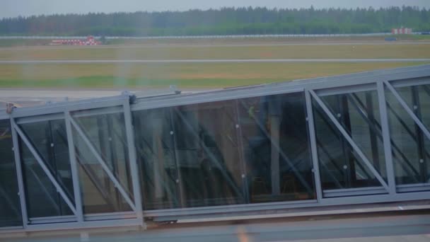 Δύο επιβάτες που επιβιβάζονται στο αεροπλάνο μέσω μιας αερογέφυρας. — Αρχείο Βίντεο
