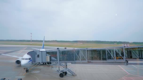 Посадка пассажиров на самолет через воздушный мост . — стоковое видео