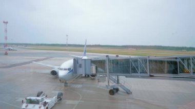 Uçak uçuş ve uçak teknisyeni, uçaktan airbridge ayırma kontrol önce yakın çizim traktör. 4 k görüntüleri.