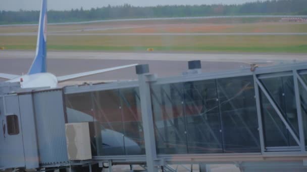 Silhuetten av två passagerare ombordstigning på flygplan genom en airbridge. — Stockvideo