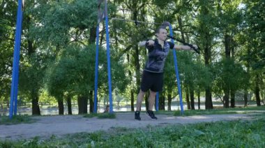 fitness döngüler bir yaz parkta Push-up egzersizleri yapma genç adam. 4 k yavaş önden görünüm görüntüleri