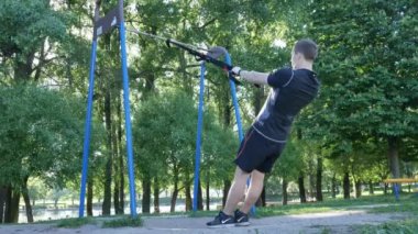 adam pull-up fitness döngüler yaz Park üzerinde egzersiz yapmaya başlar. 4 k ağır çekim görüntüleri