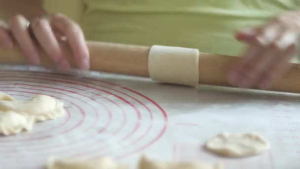 Woman is rolling a dough with a rolling pin, clouse up — Stock Video