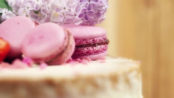 Décoration rotative à la main avec macarons, fraises et lilas, 4K slow mo close — Video