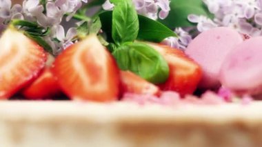 Pasta dekorasyonu macaroons, dilimlenmiş çilek ve Lila çiçek, 4 k yavaş mo ile döner yakın çekim