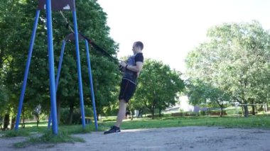 yoğun pull-up fitness üzerinde egzersiz yapan erkek rüzgarlı yaz parkta döngüler. 4 k ağır çekim görüntüleri
