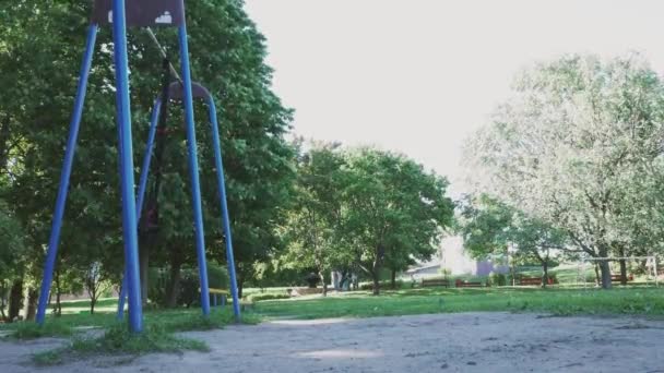 Zwei Fitnessschleifen wiegen sich im Wind auf einem Sportplatz im Sommerpark — Stockvideo