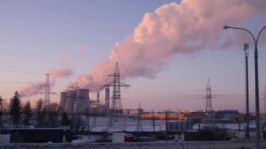 Duman ve buhar, elektrik santralinin üç borusundan kış gökyüzüne yükseliyor.