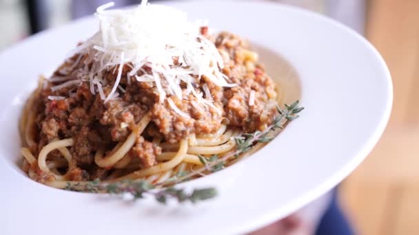 Bolognese pasta met Parmezaanse kaas op een bord versierd met rozemarijn 4k slowmo camera beweging — Stockvideo