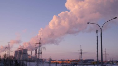 Duman ve buhar, elektrik santralinin üç borusundan kış gökyüzüne yükseliyor.