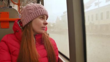 Yakın çekim shot genç bir üzgün kadın otobüsle seyahat sıkıcı yağmurlu bir günde. O ıslak pencereden dışarı bakarak ve ağır nefes. Büyük bir şehirde yalnızlık