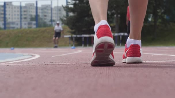 若い女性アスリート陸上競技で実行が開始赤 snikers で足を 4 k Uhd カメラでビデオをスローモーションでトレーニングを閉じる日追跡します。 — ストック動画