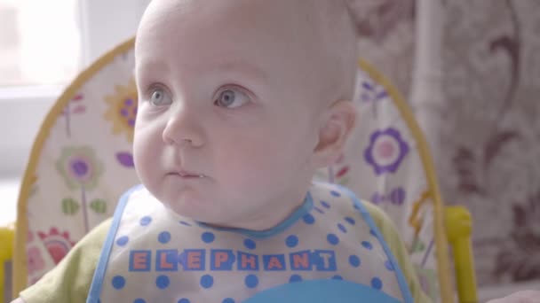 Moeder geeft haar schattige kleine baby jongen sommige granaatappel bessen, zoon eten ze en vervolgens spits uit het grimassen close-up weergave slow-mo video in 4k — Stockvideo