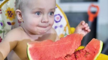 oturan güzel bebek çocuk kadar görünüm yavaş mo 4 k'dan fazla video kamera seyir ve bir parça kırmızı karpuz yeme çocuklar tabloyu kapatın