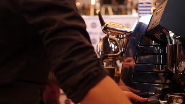 Uomo barista macina chicchi di caffè per fare il caffè in macchina da caffè moderna mentre la donna barista prepara caffè da asporto caldo in una cucina del caffè 4K rallentatore close up video — Video Stock