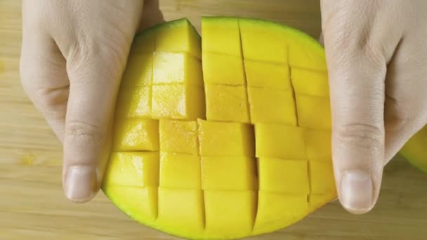 Las manos de mujer joven despliega mango amarillo cortado en cámara lenta primer plano de vídeo en 4K — Vídeo de stock