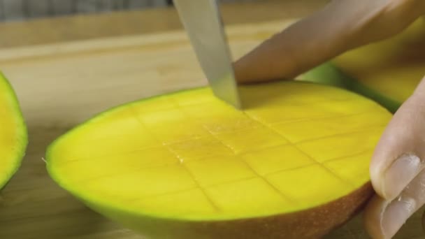 4 k でビデオを閉じる作品スローモーションによって黄色のマンゴーをカットする女性の手 — ストック動画