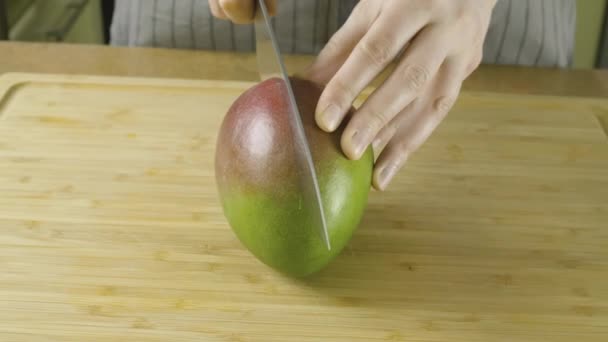 Женские руки разворачивается разрезанный на куски свежий желтый манго в крупным планом видео в 4K — стоковое видео