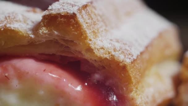 Primer plano de vídeo de mujer dedo está presionando galletas eclairs francés con crema roja y blanca espolvoreada con azúcar en polvo en 4K cámara lenta — Vídeo de stock