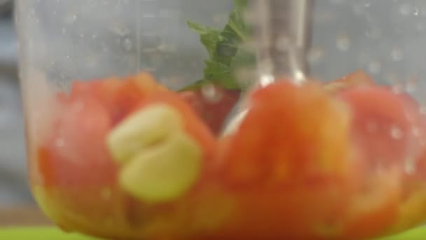 Женщина или мужчина режет овощи блендером для соуса. Здоровое питание — стоковое видео