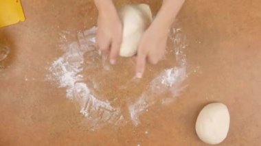 üst görünüm zaman atlamalı 4k video bir kadın şef tarafından kahverengi bir masada peynir ile peperoni pizza yapma