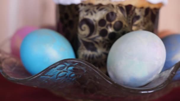 Un pastel de Pascua tradicional decorado con huevos de Pascua de colores están girando en una hermosa placa de vidrio sobre fondo de madera en cámara lenta primer plano 4K video sin personas — Vídeos de Stock