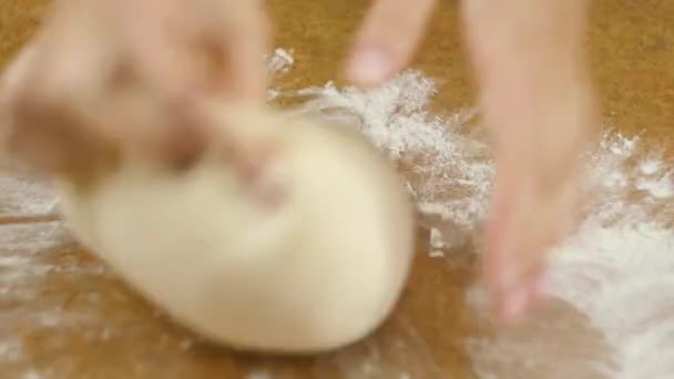 Homem ou mulher chefs mãos amassar a massa de pizza na mesa marrom close up foco seletivo 4K vídeo . — Vídeo de Stock