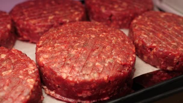 바베큐를위한 신선한 쇠고기와 치킨 커틀릿은 슬로우 모 카메라 모션 4K 비디오에서 고기 섹션의 상점 선반에 검은 쟁반에 누워 있습니다. — 비디오