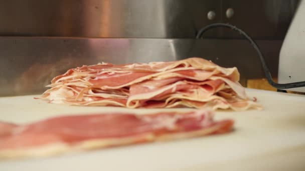 Man or woman butcher hands are laying out the bacon bits on the store shelf for sale in slow mo close 4K vídeo — Vídeo de Stock