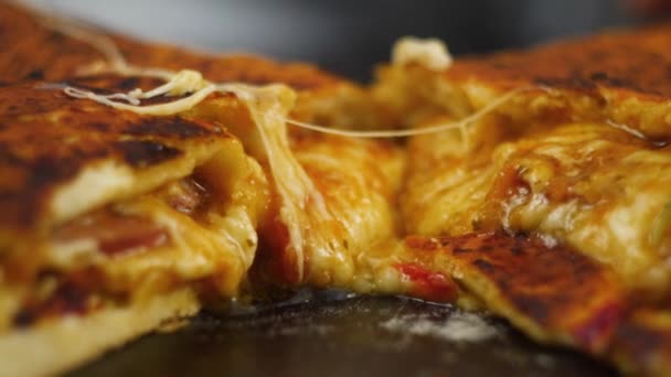 Čerstvě připravovaný teplý peperonový Pizza s taveným sýrem na dřevěném stole ozdobeného bazalkou v rukou muže nebo ženy šéfkuchaře v pomalém pohybu zblízka pohled 4k video