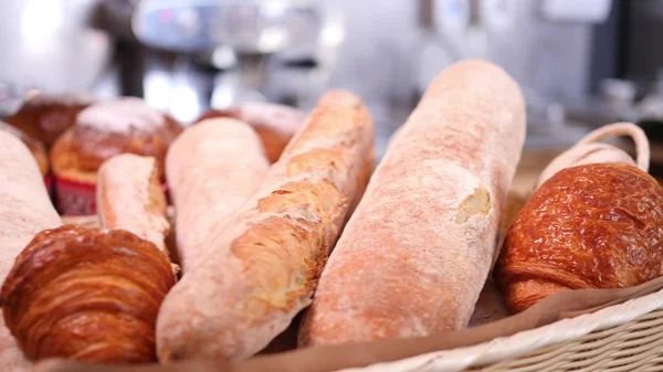 Breads and other bakery in decorative basket on wooden bakery shelve in background slow motion close up shot in 4K — Stock Photo, Image