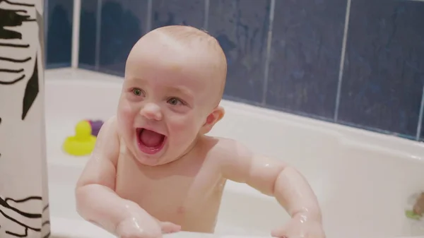 Baby-Junge hat Spaß im Bad lächelnd und spielend mit seiner Mutter, die hinter der Kamera in Zeitlupe Medium schoss 4k Filmmaterial. — Stockfoto