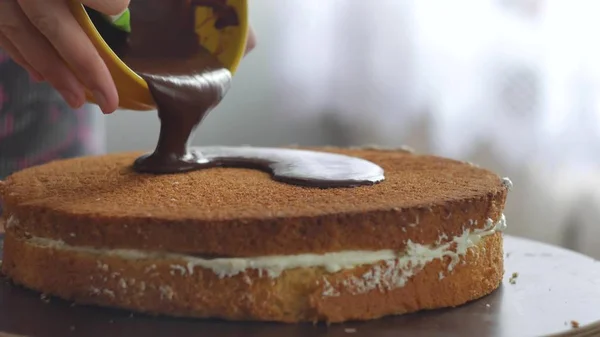 El krem çikolata kek üzerine dökün ve yayılmaya başlar.