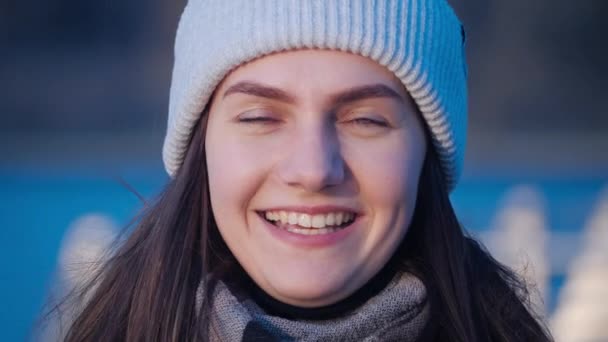 Positieve mooie vrouw portret van groene eyed lang haar brunette meisje die gelukkig glimlacht en kijkt rond en op de camera met een meer op de achtergrond in close-up 4k video. — Stockvideo