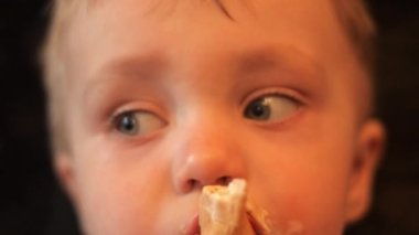 vanilyalı dondurma waffle fincan yeme sevimli bir bebek çocuk ve çocuk kamera içine bakar ve yavaş hareket portre kendini 4k video yakın.