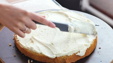 Kız bir krem berry bırakır. Hazırlamak kek krem ve Frenk üzümü çikolata ile bir pasta hazırlanıyor.