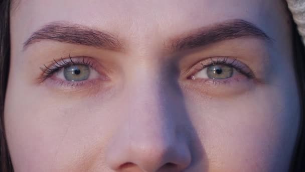 Close up retrato de olhos verdes de jovem mulher bonita que está assistindo na câmera e, em seguida, olha para o pôr do sol luz em câmera lenta vídeo de fundo 4K . — Vídeo de Stock