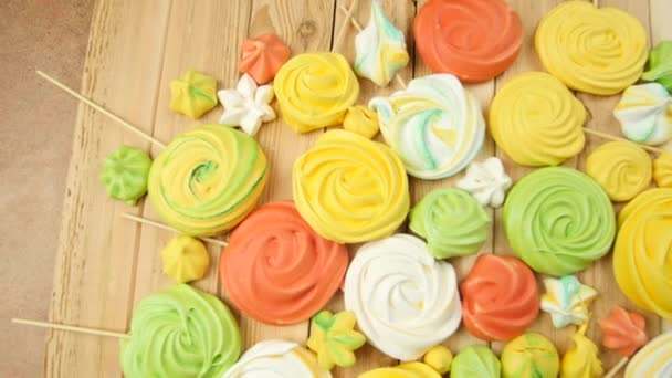 Muchos diferentes soufflés dulces de colores para la decoración de la torta se encuentran en la mesa de madera en el fondo en cámara lenta cerca de vídeo 4K — Vídeo de stock