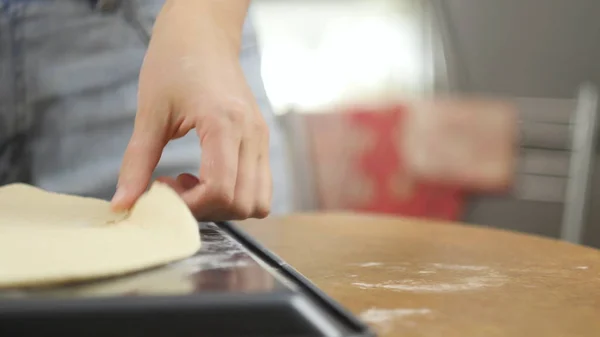 ピザを作る。シェフはピザ生地を準備します。おいしいピザを作るために男か女が家内経営に従事している — ストック写真