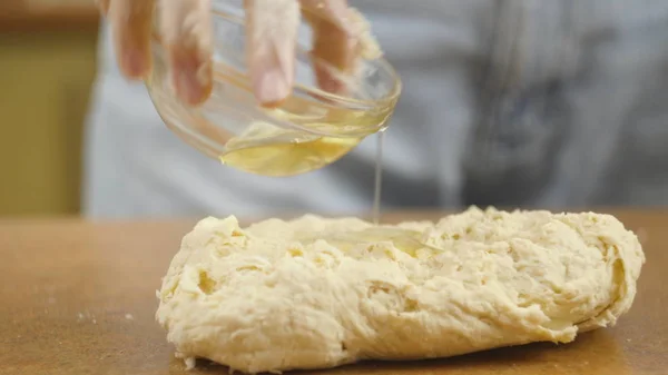 Mujer madre o hija en la mesa de la cocina hace pizza comida doméstica, las manos trabajan y empujar agitar amasar la masa, enfoque selectivo dolly shot — Foto de Stock