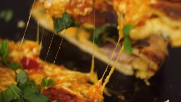 Крупный план руки шеф-повара, берущего вкусный кусок пиццы с сыром из огурцов салями на деревянной доске. Традиционная итальянская кухня — стоковое видео