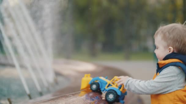 Junge spielt am Brunnen im Park. Kinderfreude, glückliche Kindheit. Familienwerte — Stockvideo