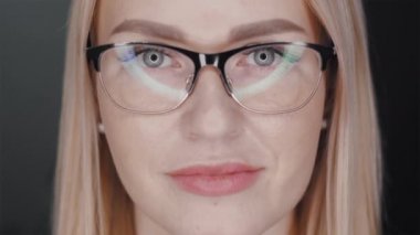 blonde girl in glasses looking at the camera. glare beauty lamps in glasses lenses