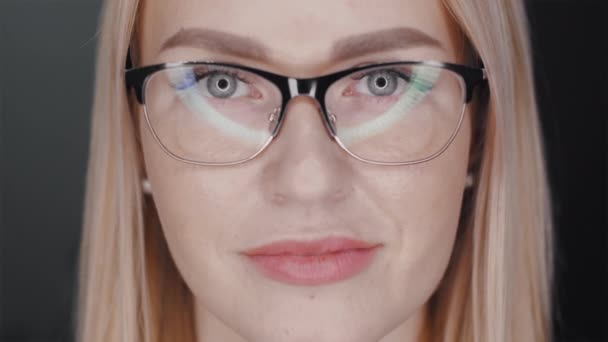 Blonde en lunettes regardant la caméra. lampes de beauté éblouissantes dans les verres — Video