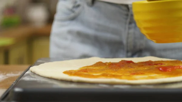 Pizza kochen. Der Koch bereitet den Pizzateig zu. Ein Mann oder eine Frau ist mit der Zubereitung einer leckeren Pizza beschäftigt — Stockfoto