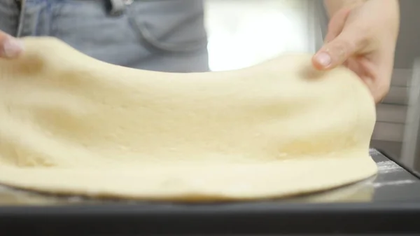 Pizza kochen. Der Koch bereitet den Pizzateig zu. Ein Mann oder eine Frau ist mit der Zubereitung einer leckeren Pizza beschäftigt — Stockfoto