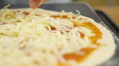 Bir erkek ya da kadın lezzetli bir pizza hazırlamakla meşgul. Pizza pişiriyorum..