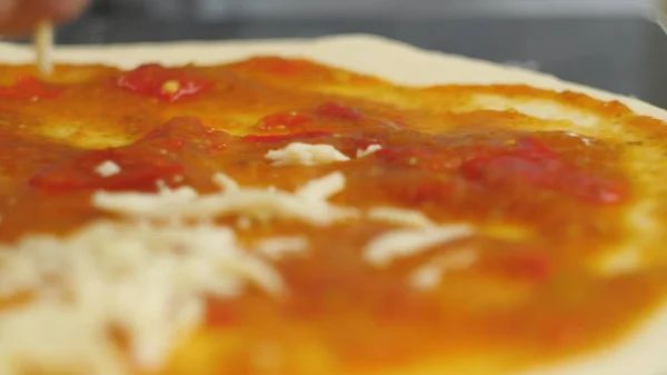 Um homem ou mulher está envolvido em negócios em casa preparando uma deliciosa pizza. Cozinhar pizza. — Fotografia de Stock